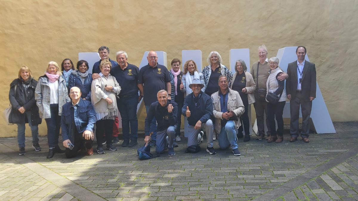 Grupo de visitantes frente a las letras del museo y acompañados por el técnico Jesús Duque